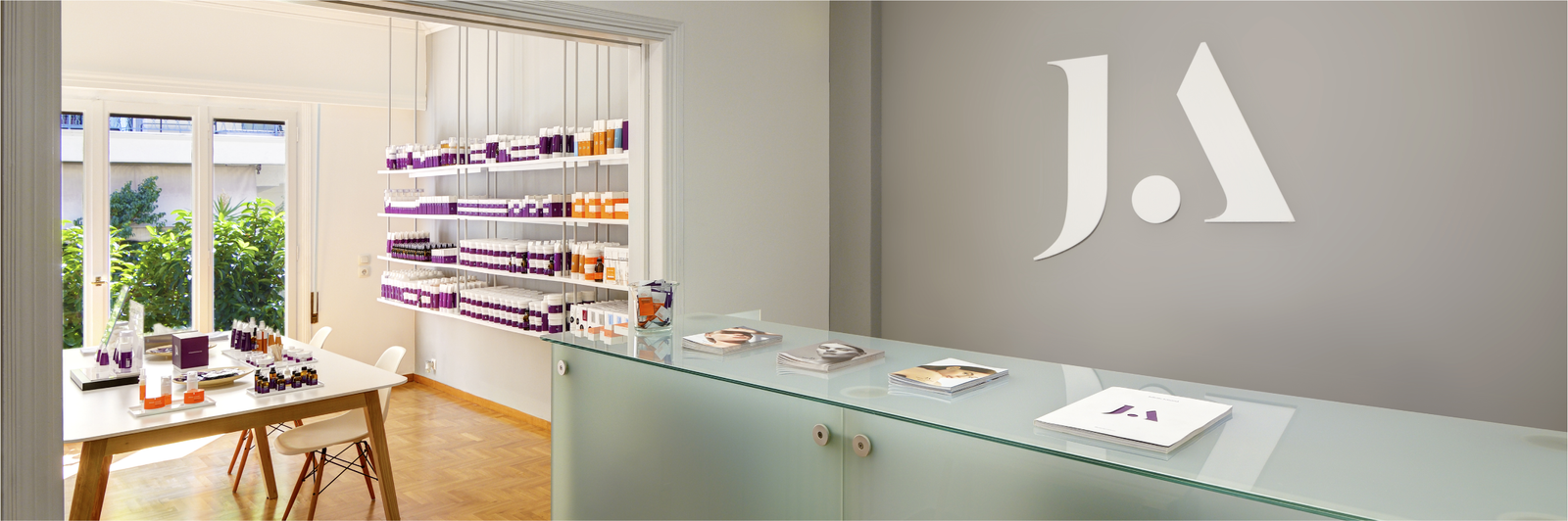 Modern interior design with shelves with JJA Peeling Protocols, a desk, and a JA logo on the wall.